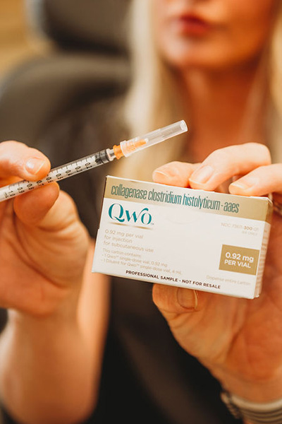 Woman holding a box of QWO injections